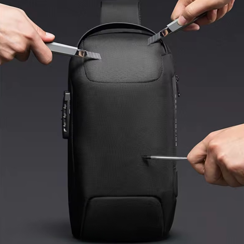 Knifes trying to break into the black minimalistic anti-theft crossbody bag with built-in lock and external USB charging port.